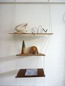 Xin Cheng, a string shelf of rag string, plywood, cardboard, hardboard and screws and weights (brick, plastic bag of sand, limestone, concrete, scoria) holding copper wire, cotton rope, cardboard cone, plant, cedar clock and watercolour on paper.