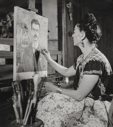 Frida painting the portrait of her father by Gisèle Freund, 1951 ©Frida Kahlo Museum   