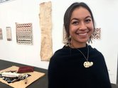 Nikau Hindin poses in front of the works she was installing at Te Uru. Image from the website of Maori TV, May 2019.